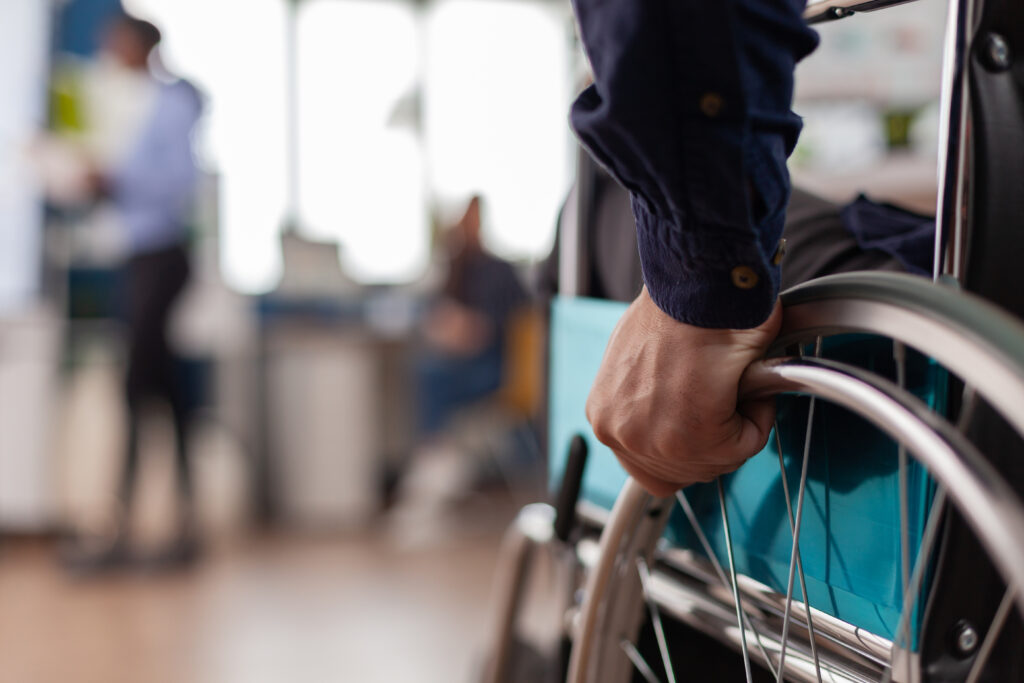 hand holding the side of a wheelchair