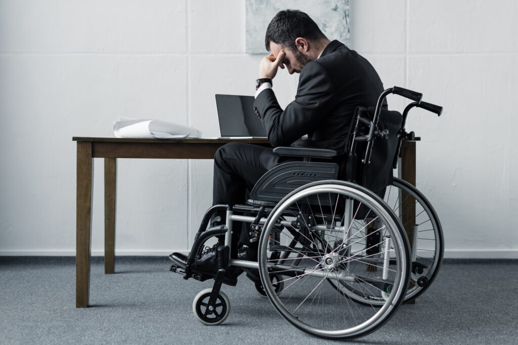 person on a wheelchair with his head down